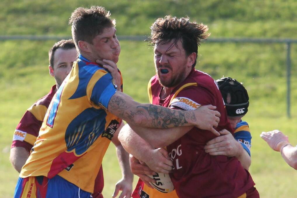 TOUGH IN CLINCHES: Dungog's Matthew Hinton tries to fend off a Kearsley defender. Picture: Jeanie Briggs