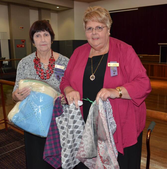 HELPING CHILDREN: Cessnock VIEW Club members Judith Wright (holding a blanket the club raffled to raise funds for the Smith Family) and Kathy Williams (with some of the library bags club members have made to donate to school children). Picture: Krystal Sellars