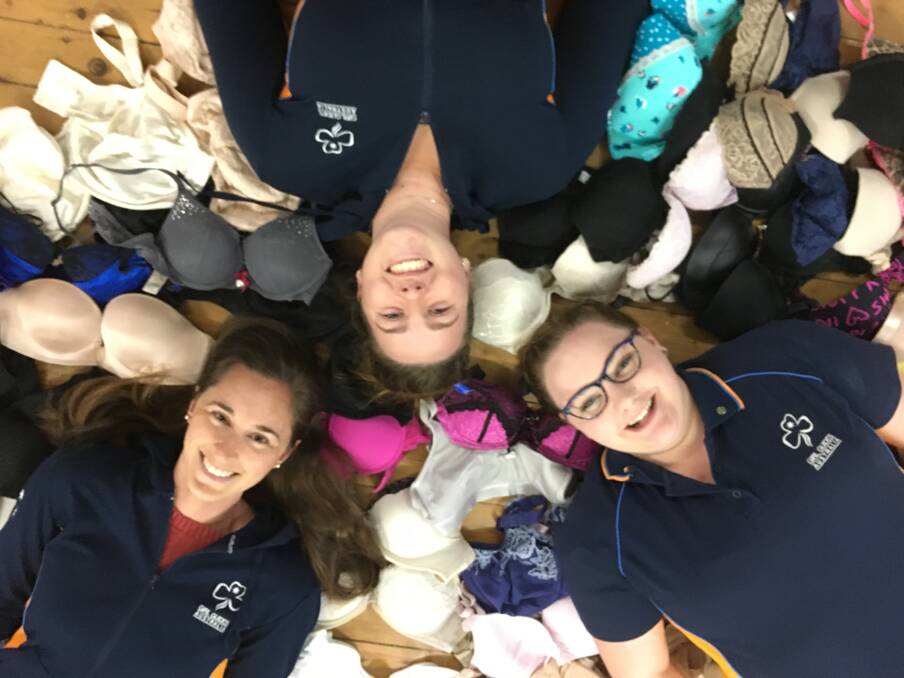 UPLIFTING: Cessnock Olaves Alexandra Wieckowski, Lauren Gray and Ainslie Griffin with some of the bras they have collected so far. Picture: Kylie Gray