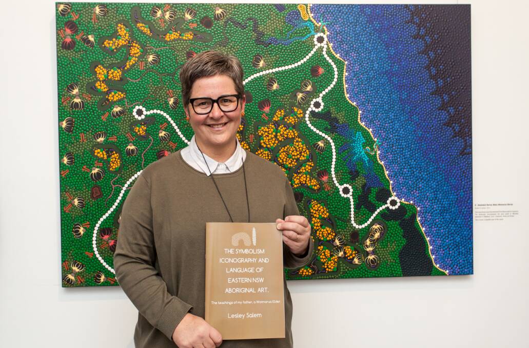 KEEPING LANGUAGE ALIVE: Lesley Salem with a copy of her book 'The Symbolism, Iconography and Language of Eastern NSW Aboriginal Art' at the opening of her exhibition at Cessnock Regional Art Gallery on July 8. Picture: Nicole Spears