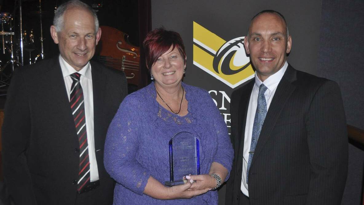 2013: Cessnock Chamber of Commerce president Geoff Walker and vice-president Barry Miller congratulate overall winner, Kim Ruggari of Mathers Shoes.