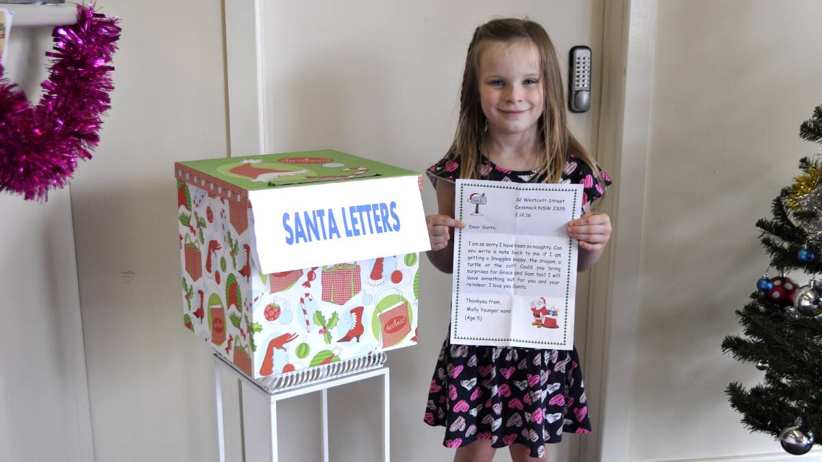 CHRISTMAS WISHES: Molly Younger, 5, drops off her letter to Santa at the Advertiser office.