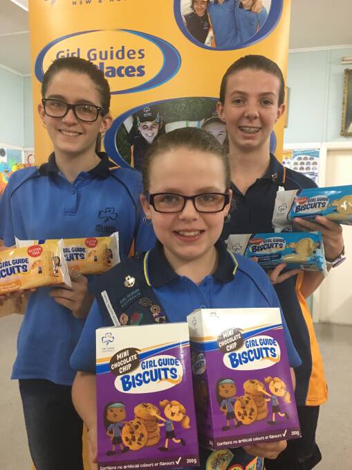 TREATS: Cessnock Guides Lilah Woolley, Tamsyn Woolley and Lucy Donn with some of the biscuits that will be for sale on Saturday.
