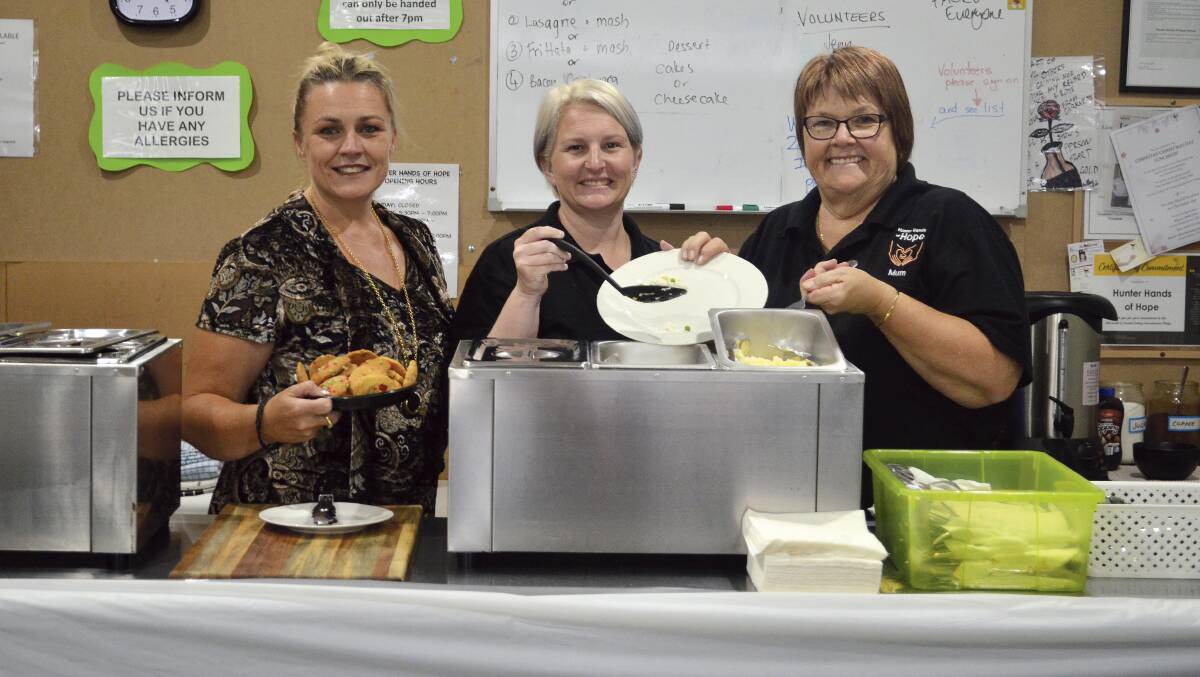 STAYING POSITIVE: Hunter Hands of Hope volunteers Melissa, Jenn and Julie dishing up a meal last week. The charity is seeking a new home for its operations from January 22 onwards.