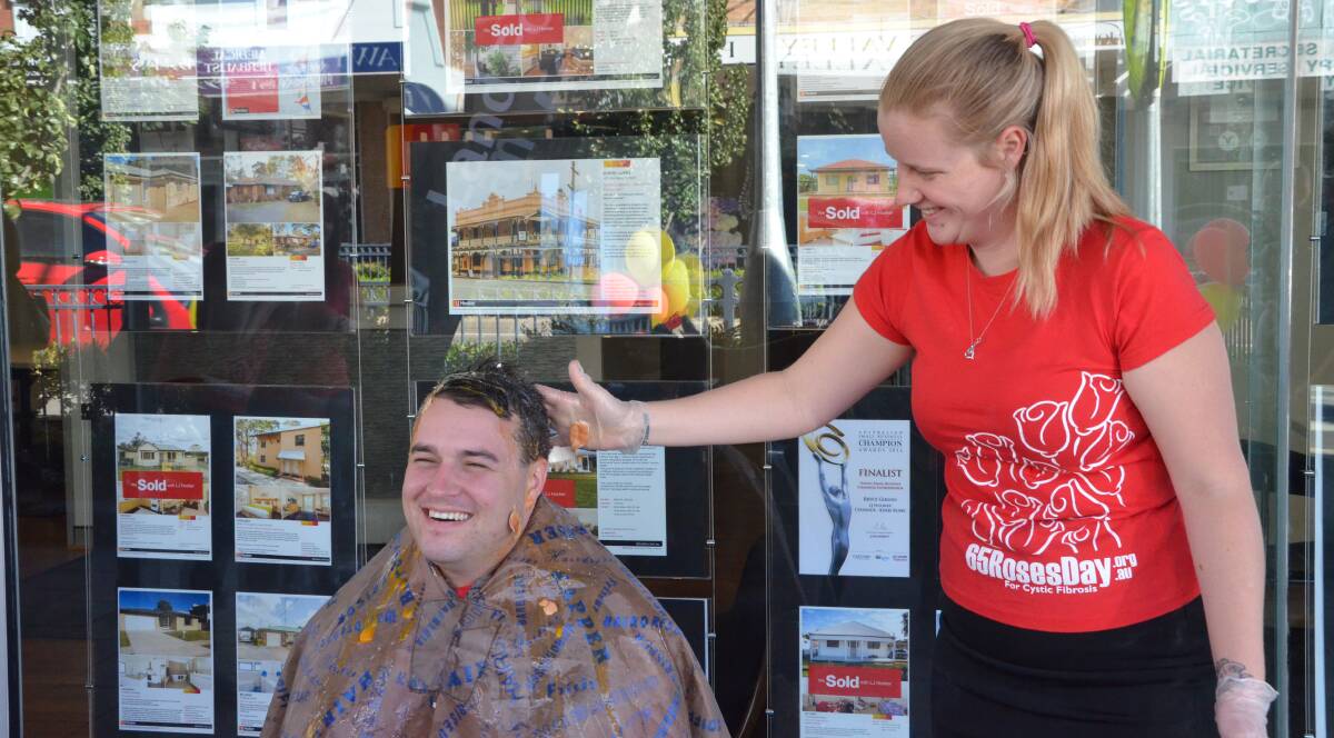 GOOD CAUSE: LJ Hooker Cessnock and Kurri admin assistant Lauren Lewis cracks an egg over principal Bryce Gibson's head for the Crack A Cure for Cystic Fibrosis fundraiser on May 27.