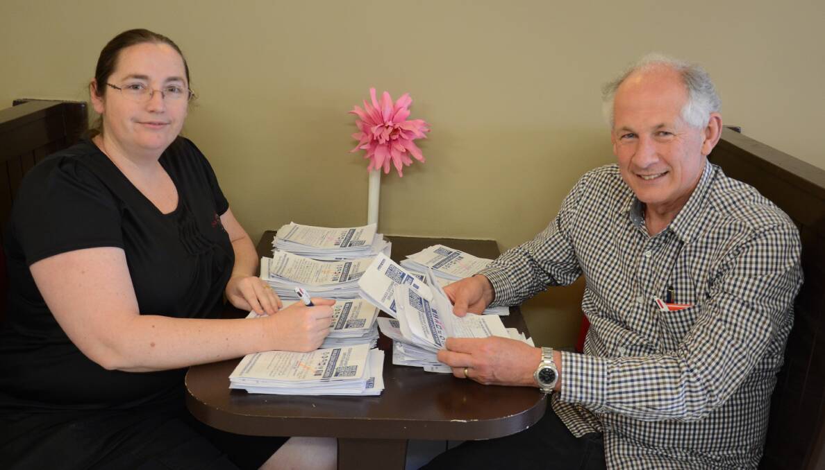STACK OF ENTRIES: Cessnock Chamber of Commerce vice-president Rienna De Visser and president Geoff Walker look over some of the entries for customer service awards.