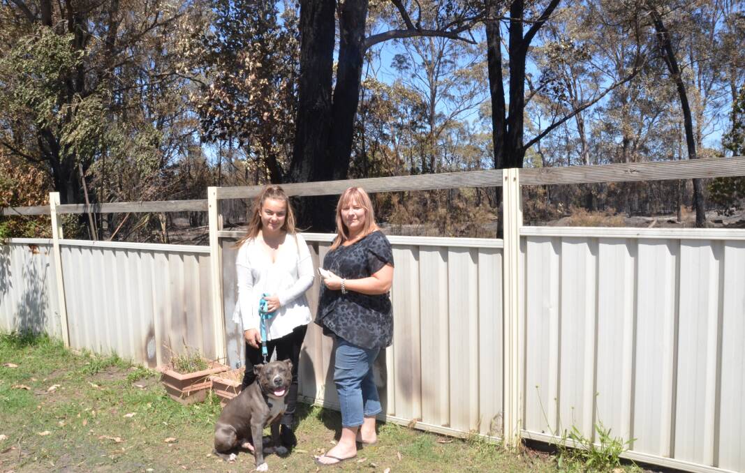 TRAPPED: Sindy Pickering, right, with her daughter Kasey, 16, and Chevy (one of the family's four dogs) at their Aberdare home which was surrounded by fire on Saturday afternoon. Picture: Krystal Sellars