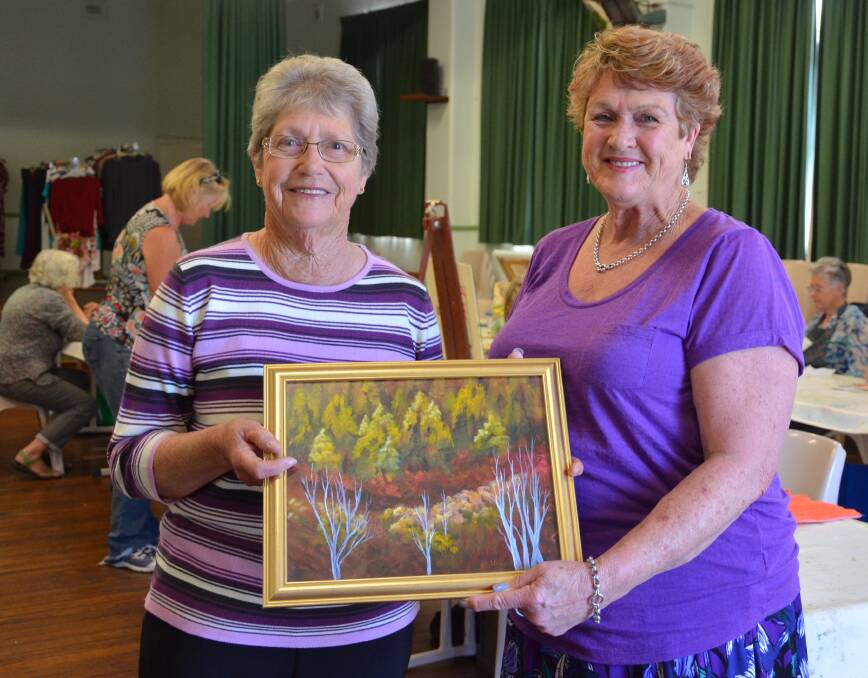 APPRECIATED: Cessnock Uniting Church Art Group member Margaret Warner presents Barbara Stewart with her prize, 'Forest in Autumn'. Picture: Krystal Sellars