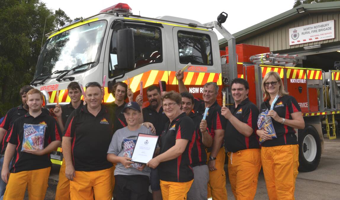 ZOOPER HEROES: North Rothbury Rural Fire Brigade members say thank you to Kurri Kurri boy Will Stothard with a certificate, hat and of course, some Zooper Doopers. Picture: Krystal Sellars