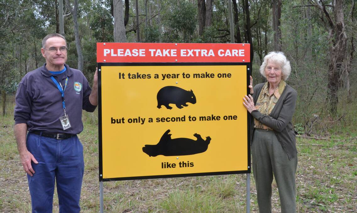 ATTENTION: Cessnock Men's Shed member Geoff Gray and Wollombi Landcare volunteer Valerie Milgate with one of the signs that will be installed around the Wollombi Valley. Picture: KRYSTAL SELLARS