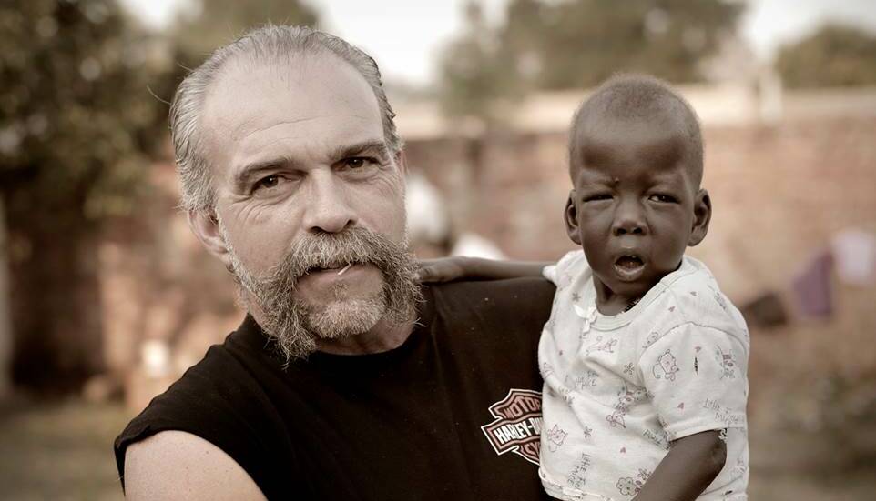 Sam Childers and child Augustino in Northern Uganda. Picture: Supplied