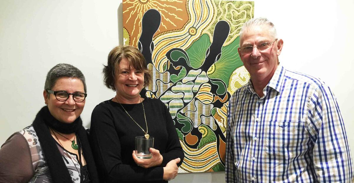 EXHIBITION: Uncle Les's daughters Lesley Salem and Kerry Kirk with Mayor Pynsent in front of Platypus (winner of the 2015 Weston Art Prize), which hangs at Cessnock City Council.
