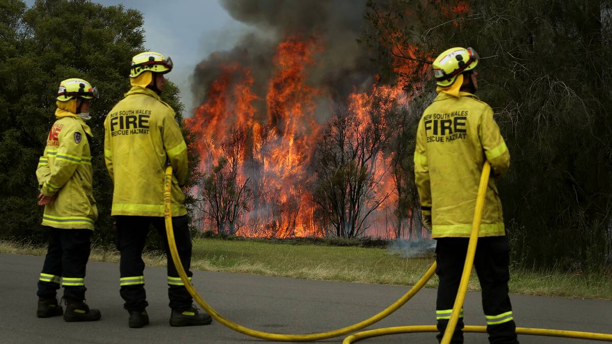 BATTLE: Fire and Rescue NSW crews ready to take on the massive blaze as it takes hold near Hospital Road. Well over 100 firefighters were on duty again in the Coalfields.