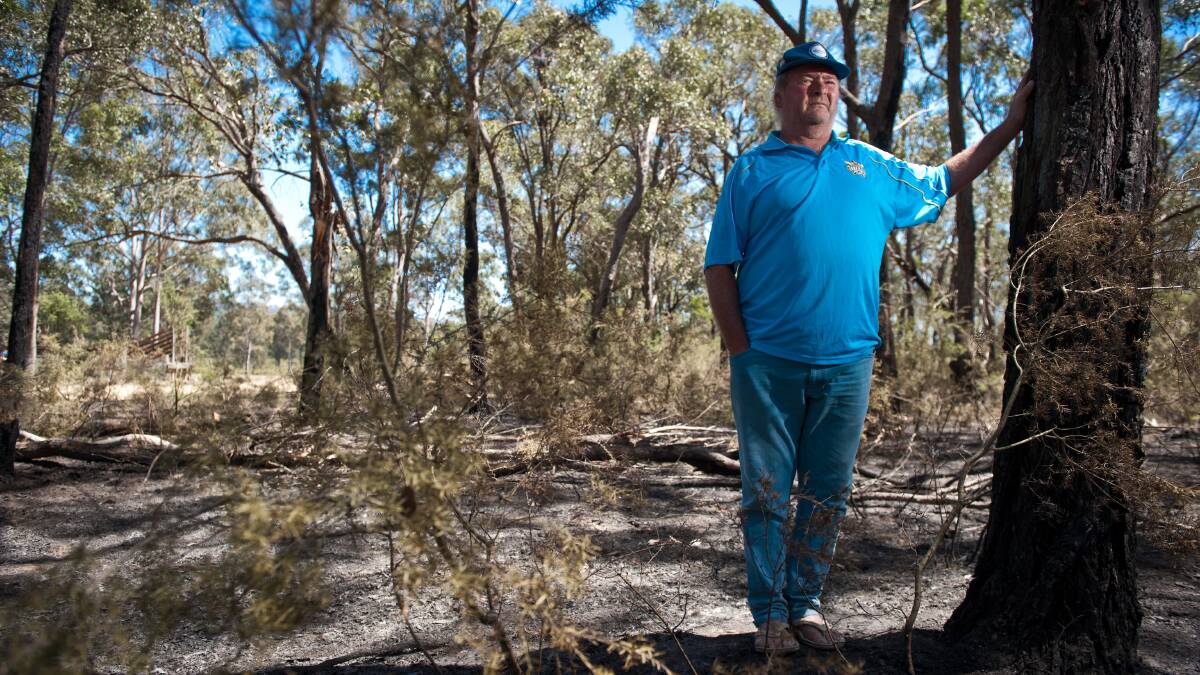 SAFE: Billy Sinigoy stands in burned bushland near his home. Picture: Perry Duffin