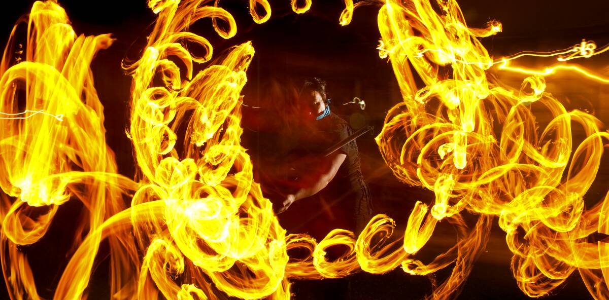 FIRE IN MOTION: Soulfire Circus fire dancer Tris "Bear" Arellano engulfed in the trails of her 'dragon' fire-staff during rehearsal. Picture: Perry Duffin
