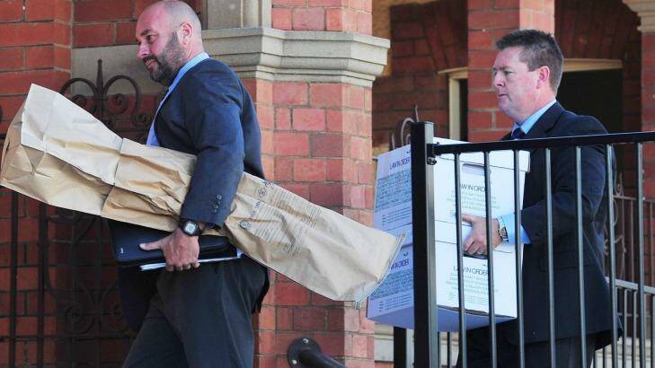 Detective Senior Constable John Cosgrove and Detective Sergeant Darren Gunn carry evidence into the Wagga courthouse, including what is believed to have been a shotgun involved in the deaths of the Hunt family.  Photo: Kieren L.Tilly