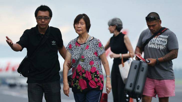 Australian Consulate staff assist Helen Chan, the mother of Bali Nine member Andrew Chan, followed by his brother Michael Chan as they arrive at Yogyakarta airport. Photo: Kate Geraghty