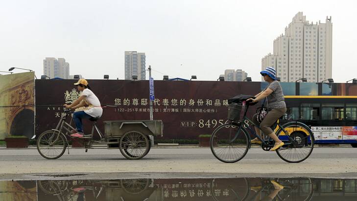 Cyclists ride past newly built residential housing in Beijing, China. Photo: Nelson Ching / Bloomberg
