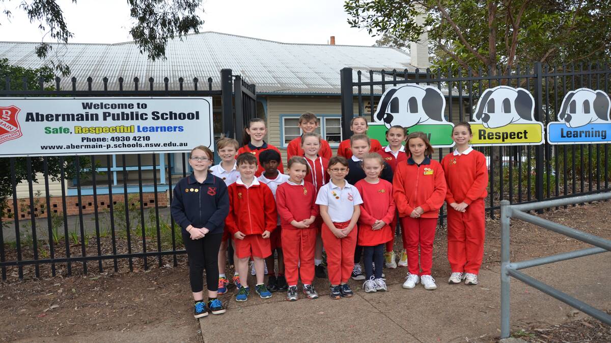 SUCCESS: Some of the 2014 PAWS Badge recipients near the new Positive Behaviour for Learning signs at Abermain Public School.
