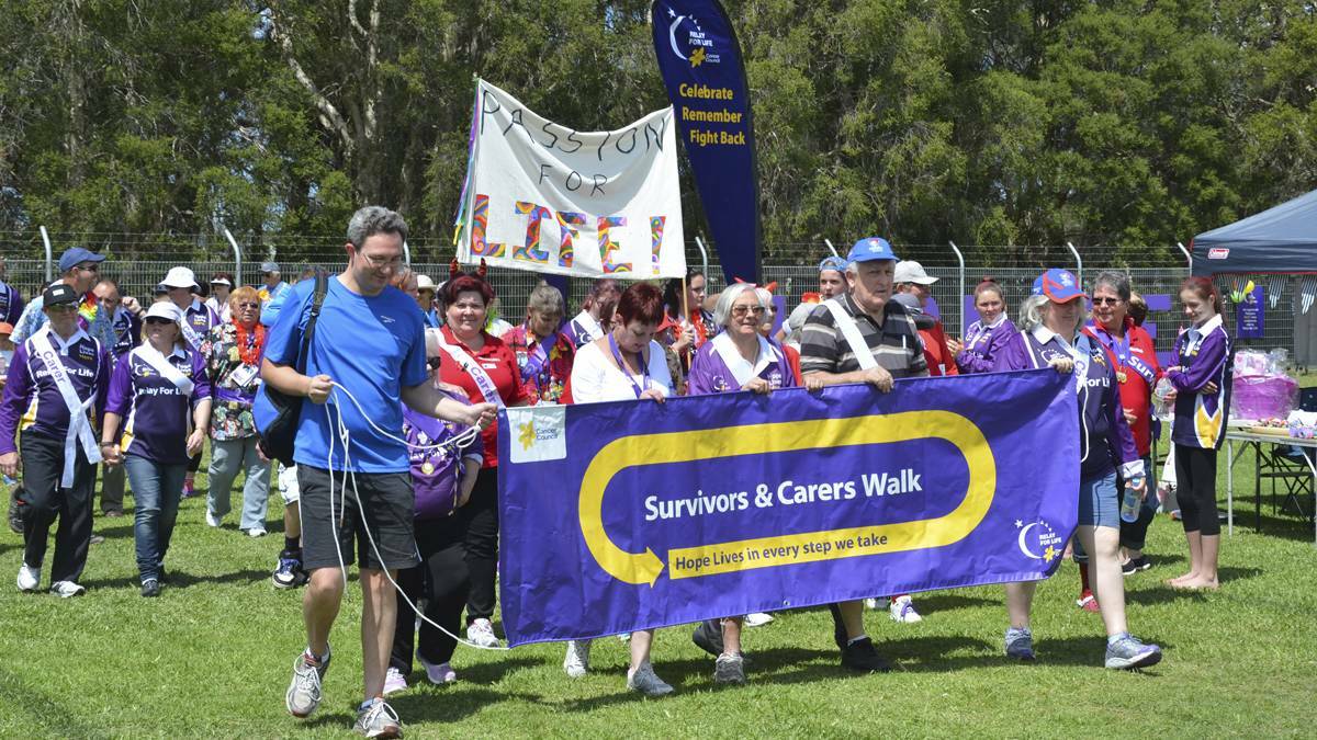CELEBRATION: Cancer survivors and carers on the opening lap of the 2014 Cessnock Relay For Life.