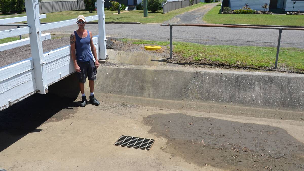 NOWHERE TO GO: Matt McIntyre in the Oliver Street drain, which overflowed during the storm on Tuesday, January 27.