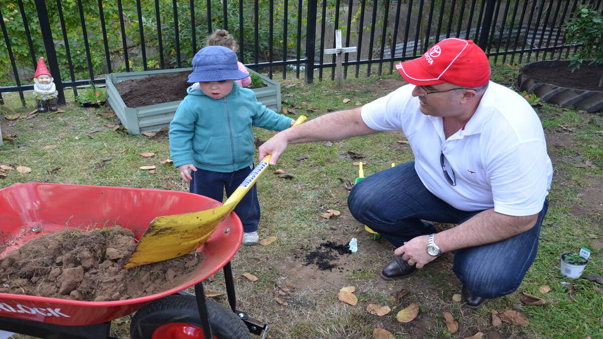 GREEN THUMBS: Cessnock Toyota general manager Gavin Allen (pictured with Oscar) lends a hand to Cessnock Multi-Purpose Children’s Centre’s tree planting efforts.