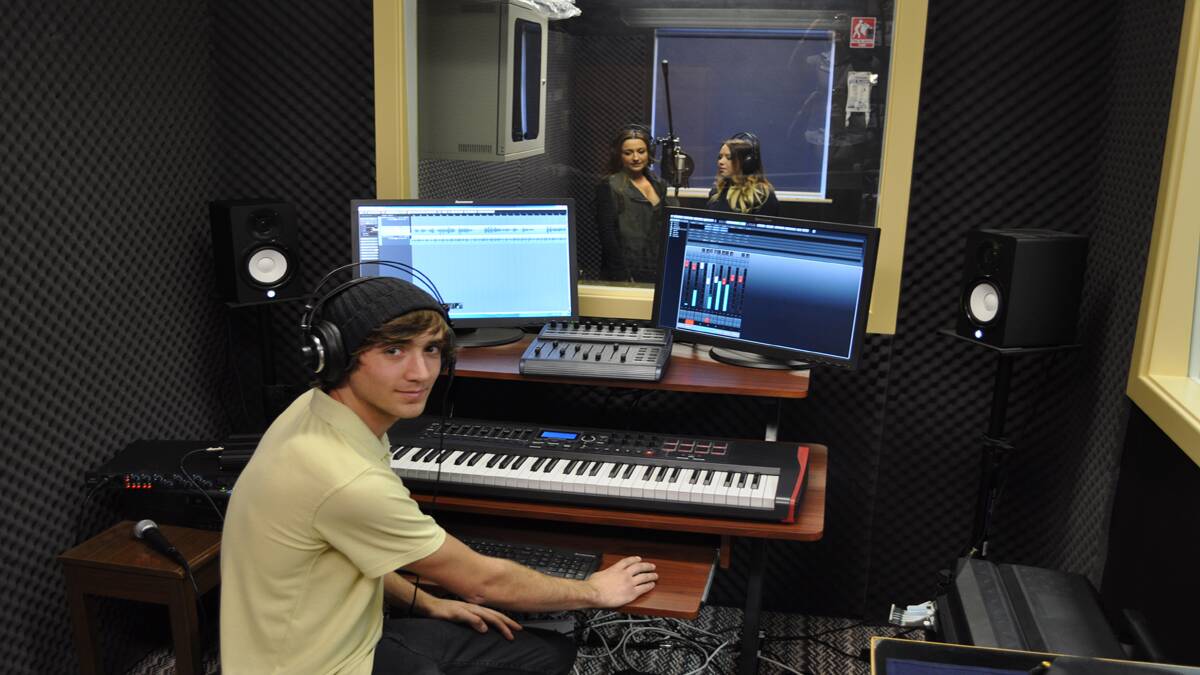 STATE-OF-THE-ART: Kurri High School students Kai Sommerville works on the production while singers Kirsty Lee Akers and Jayde Borkowski test out the new recording studio. 