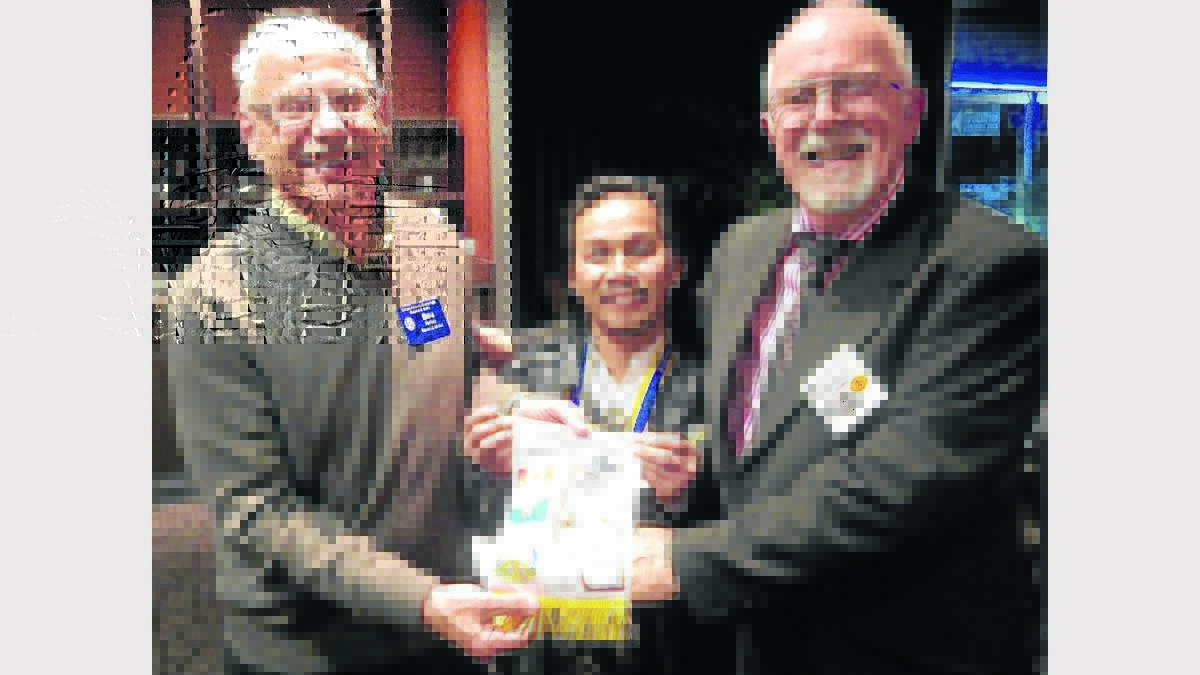 NEW PRESIDENT: Rotarian Don Parker from Alberta, Canada extends his congratulations to incoming president Noel Sugui and outgoing president, Bill Hoye.