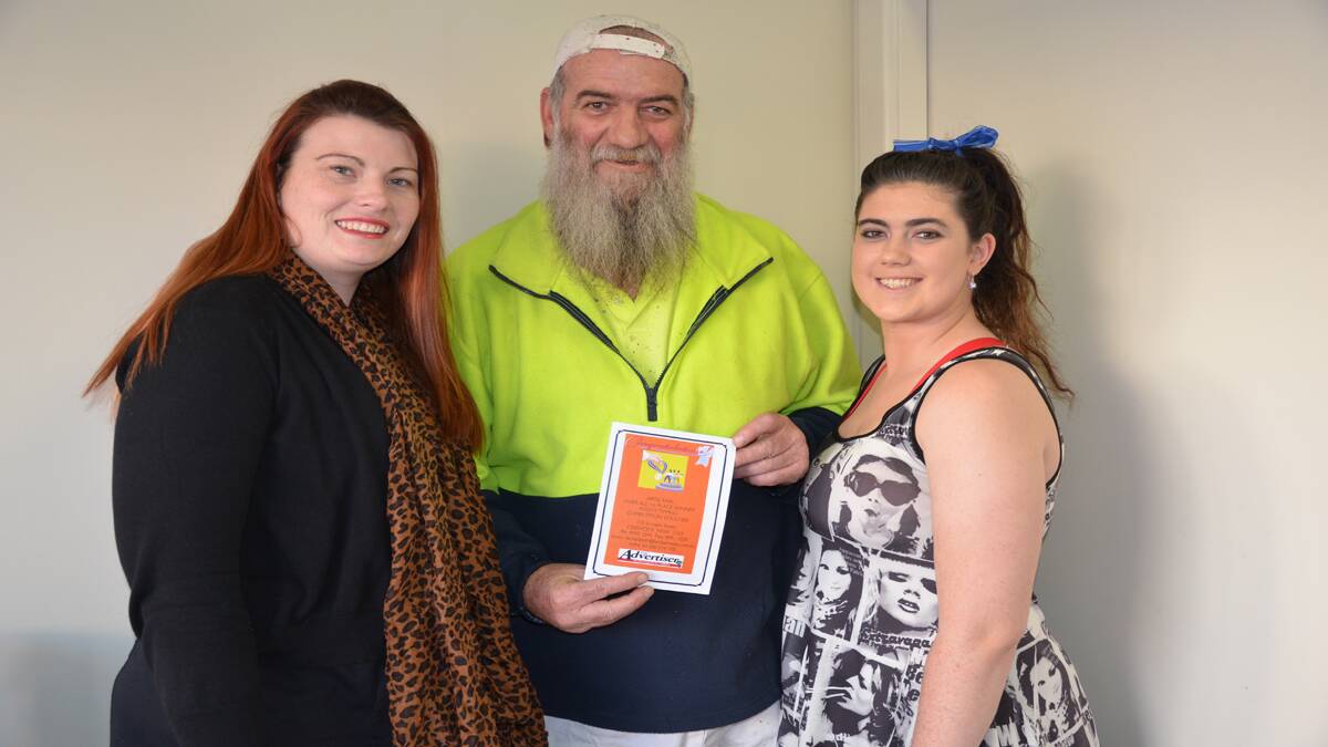TOP TIPSTER: Advertiser manager Rebecca Gillon congratulates 2014 footy tipping competition winner Artie Earl and his daughter Jazmin.