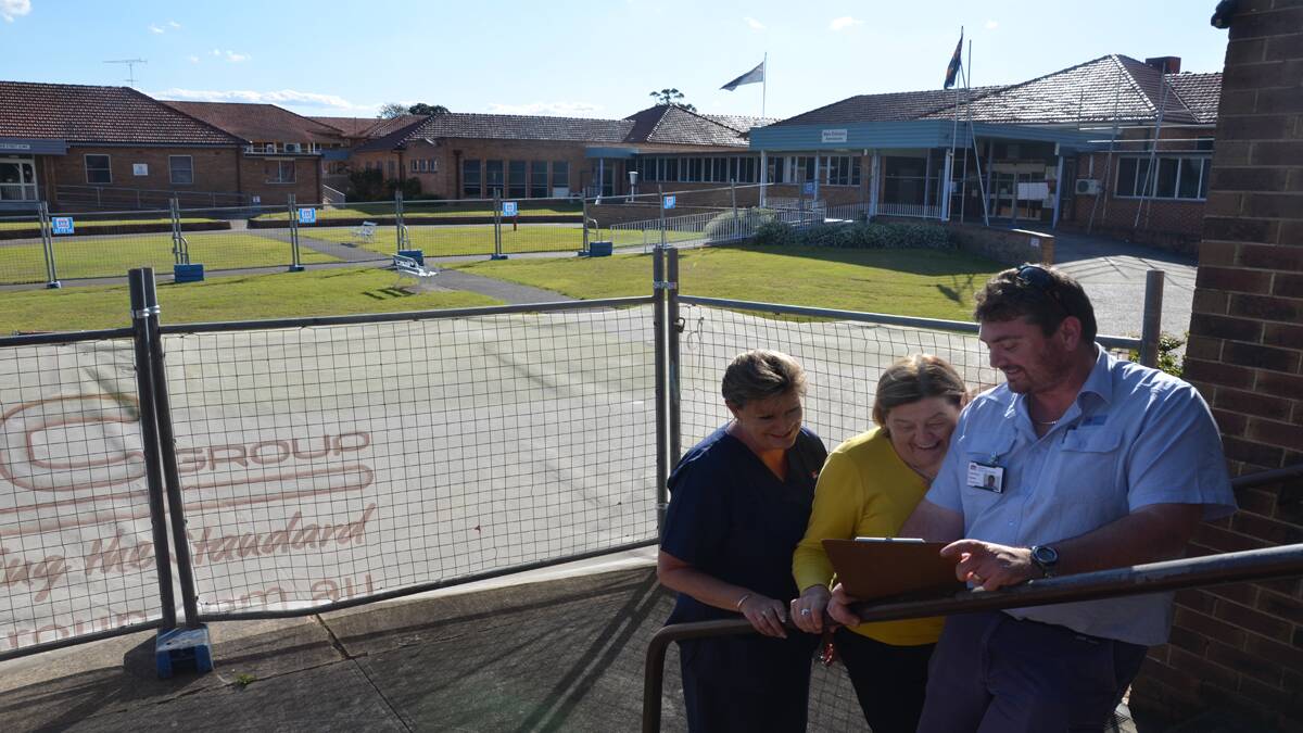 WORKS: Cessnock Hospital’s after hours manager Peg Thomson, acting work health  safety coordinator Maree Garside and Hunter New England Health engineer Justin Walker inspect the plans for the hospital’s new roof. 