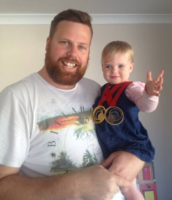 WELCOME BACK: Daniel Repacholi and his daughter Zoe, wearing his Commonwealth Games medals.