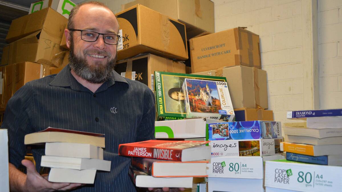 BOOKS GALORE: Cessnock Library’s customer and information services team leader Andrew Powell sorts through stock to get ready for the annual book sale.