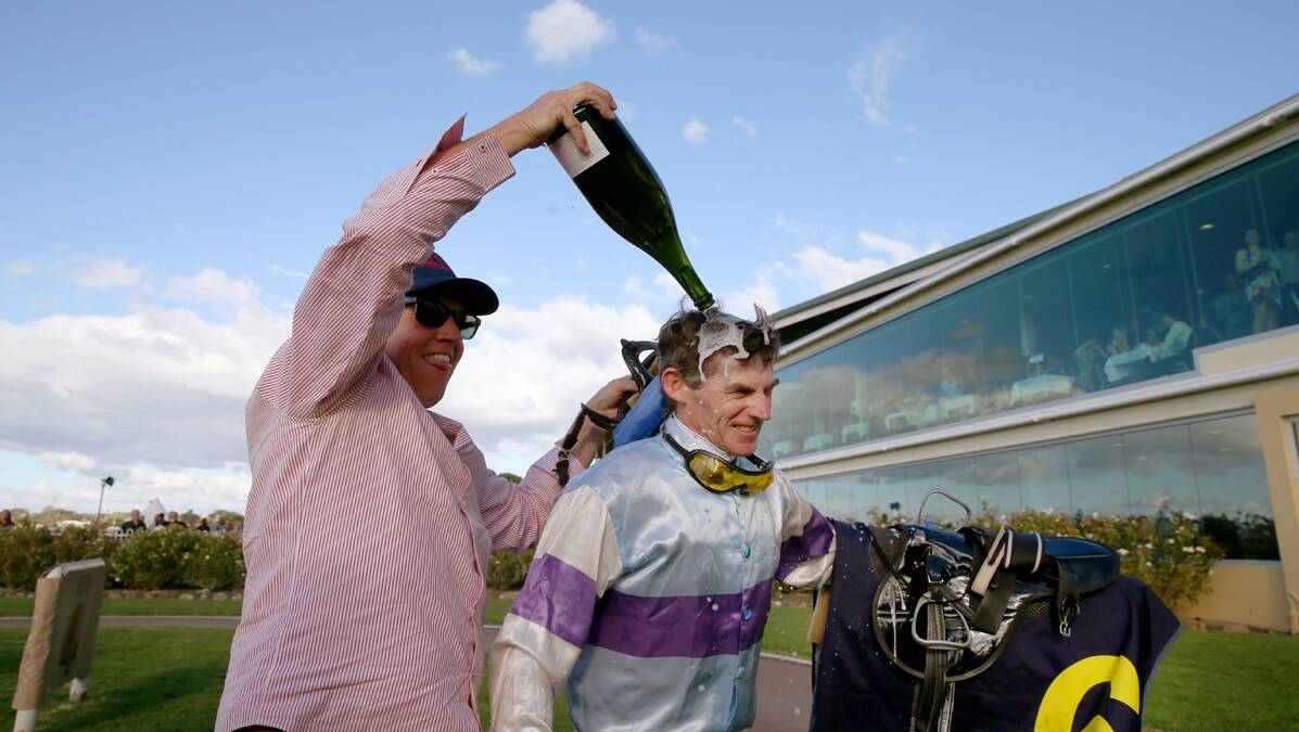 CELEBRATION: Robert Thompson is doused in champagne by his friend, Jeremy Sylvester, after his 4000th race win. Photo by Dean Osland.