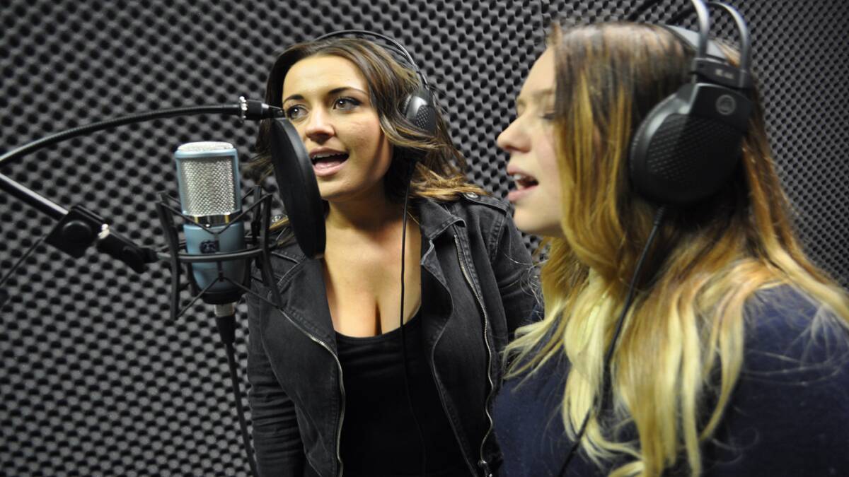 Singer Kirsty Lee Akers and Kurri High School student Jayde Borkowski test out the new recording studio. 