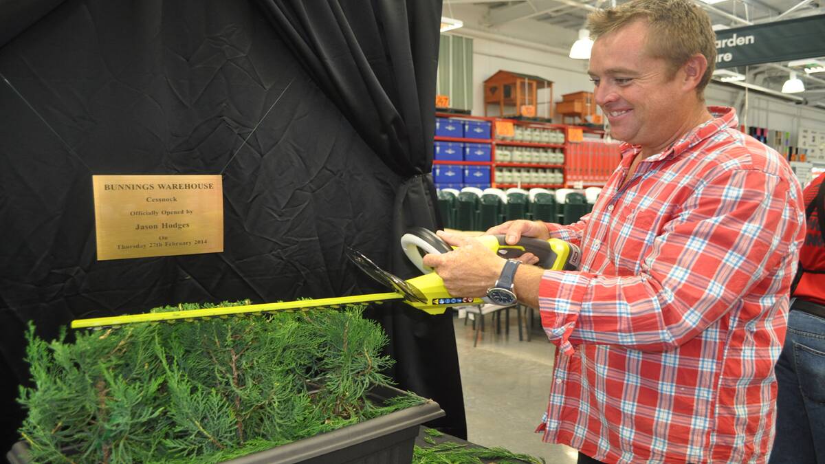 Better Homes and Gardens star Jason Hodges trims the hedge to unveil a plaque commemorating the opening of Bunnings Warehouse Cessnock. 