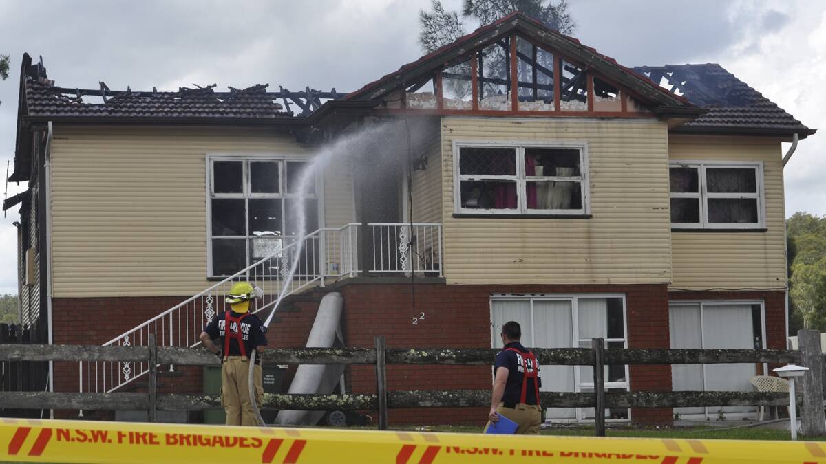 SMOULDERING: Fire crews work to contain the blaze at the home in Second Street, Millfield.