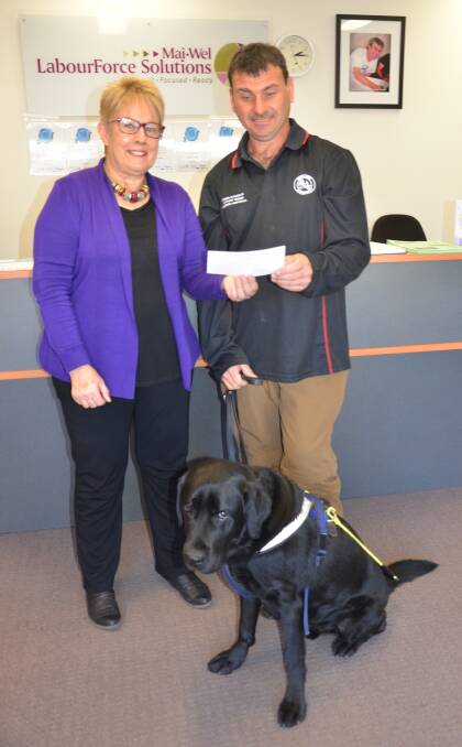 SUPPORT: Bronwyn Davis-Jones presents Greg Locock (pictured with his guide dog Pax) with a cheque from the trivia night.
