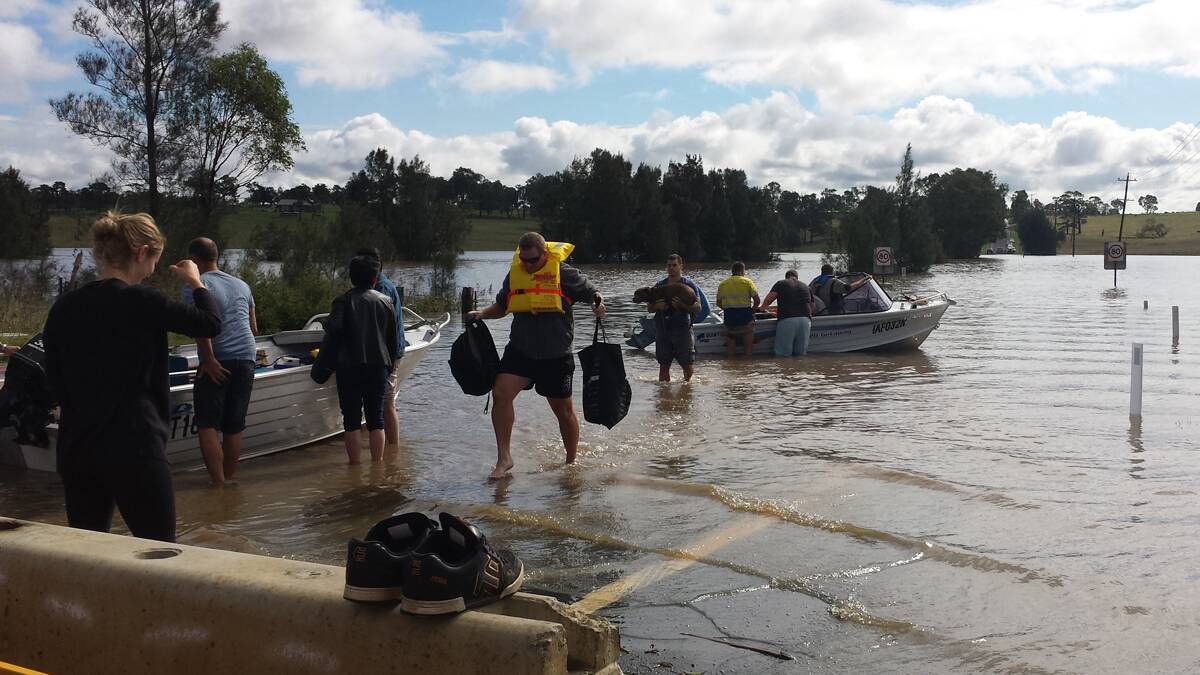 DEJA VU: Community members used boats to transport supplies to Gillieston Heights when the suburb became trapped in April 2015, which Leyland Rix remembers doing in the late 1940's.