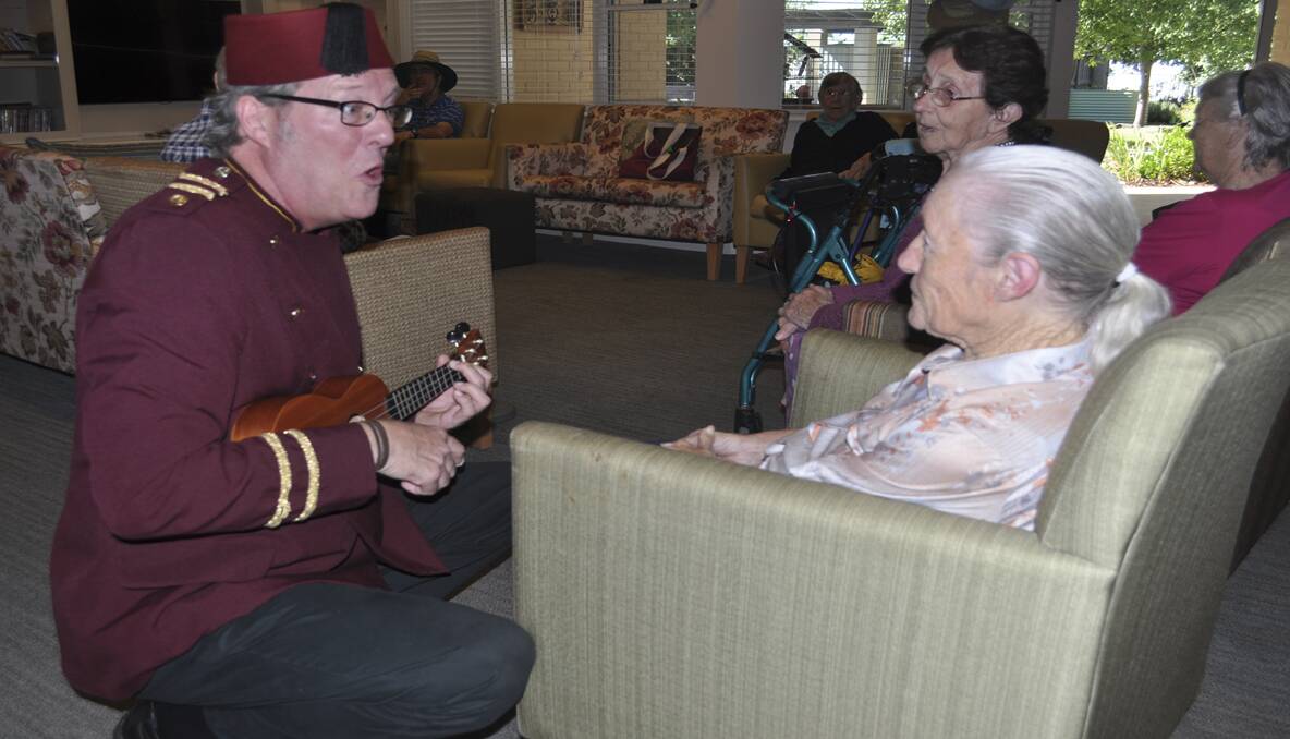 MERRY: Alan Glover plays a tune to resident Topsy Wilkins.