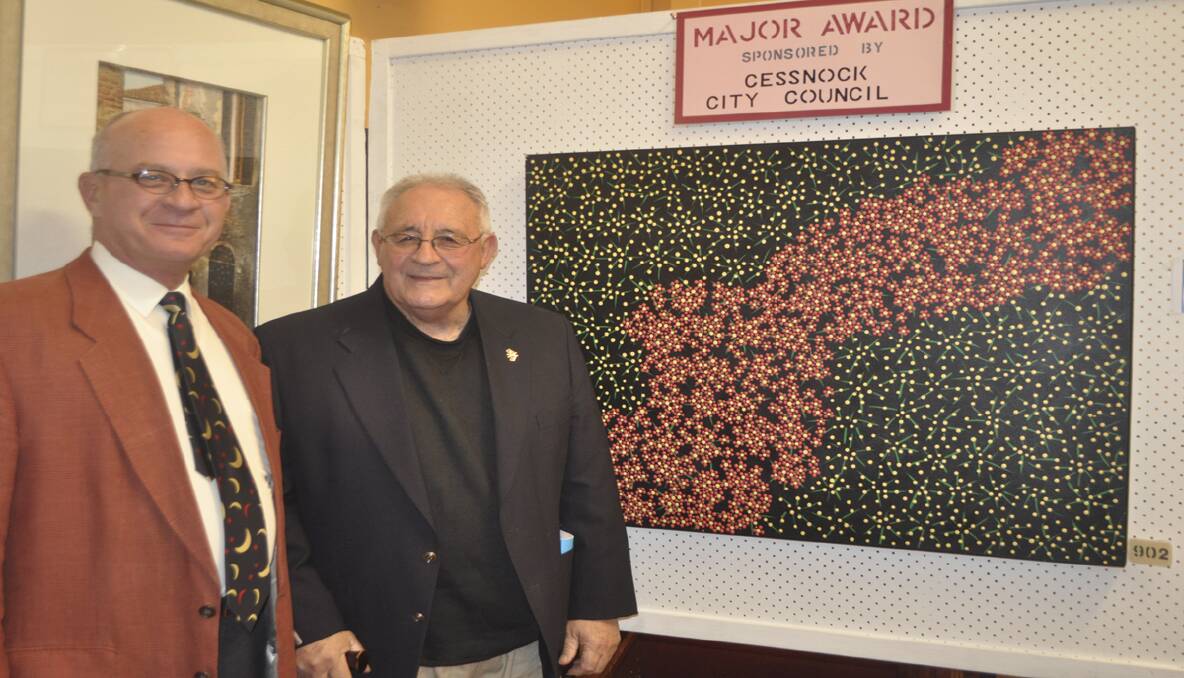 Cessnock Regional Art Gallery Director and show judge, Dr. John Barnes, and Aboriginal Elder and artist Les Elvin with the Major Award winning piece 'Christmas Bush', painted by Les's daughter Lesley Salem.  