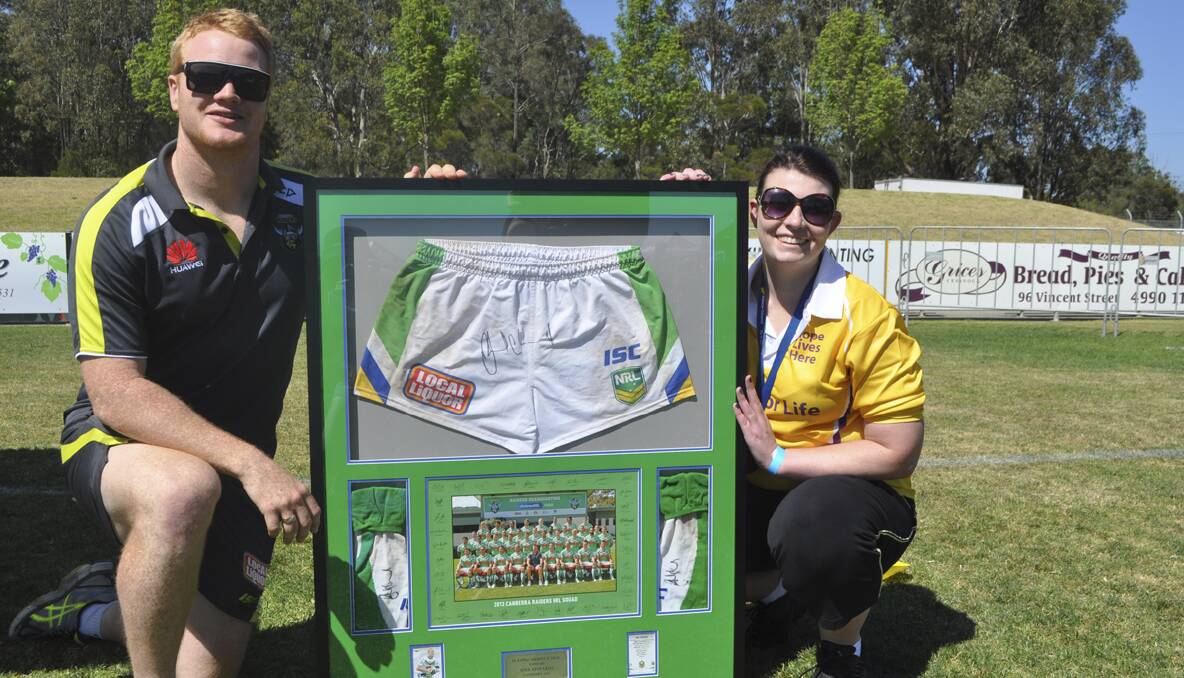 CESSNOCK RELAY FOR LIFE 2013: Cessnock-raised Canberra Raiders forward Joel Edwards donated some signed merchandise to the Relay that raised more than $600 at auction. He is pictured with Advertiser manager and Relay For Life committee member Rebecca Gillon. Photo: The Advertiser.
