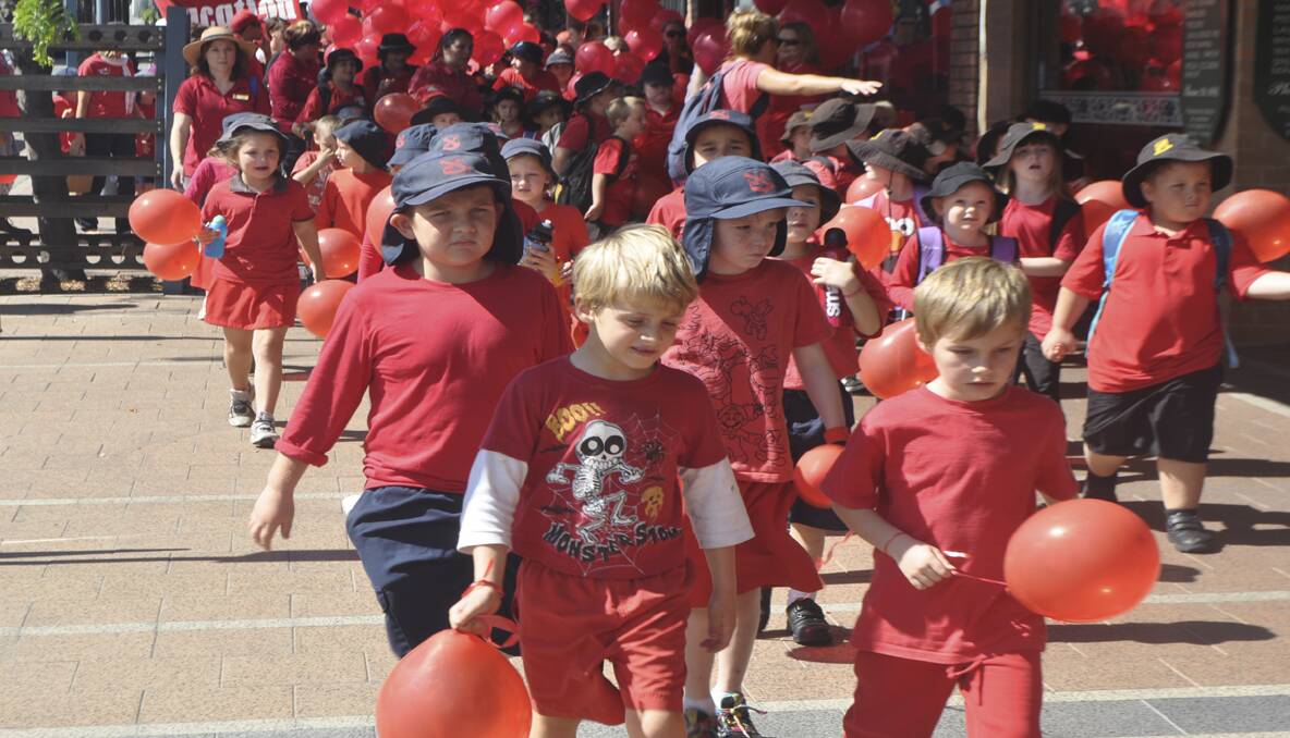 Students dressed in red walking down Cooper Street. 