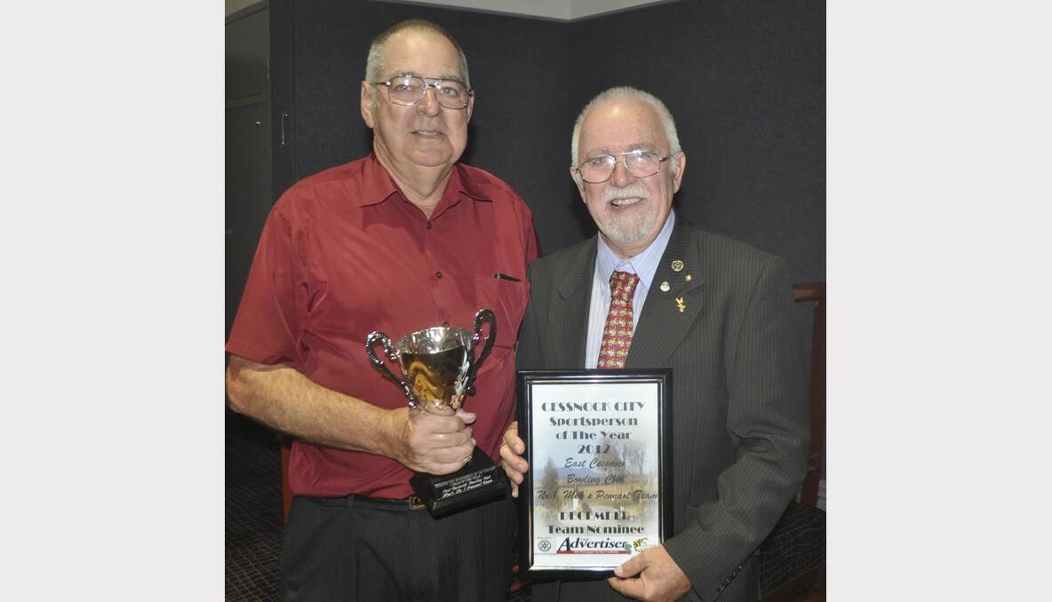 East Cessnock Bowling Club patron Sam Clough receives the Team of the Year trophy from Cessnock Wine Country Rotary Club representative Bill Hoye. 