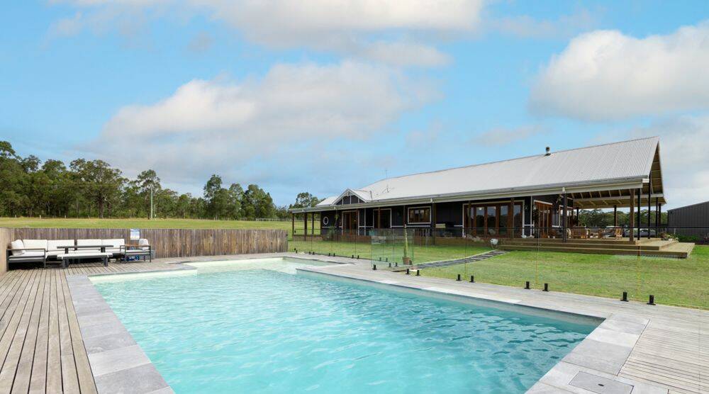 An in-ground swimming pool with a large sun deck is positioned next to the home. Picture supplied