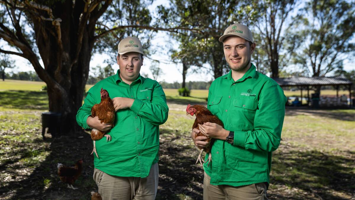 Left to right, Haynes Baird and Ethan Harrington with their hens at Haynes Farm at Pokolbin. Picture by Marina Neil. 