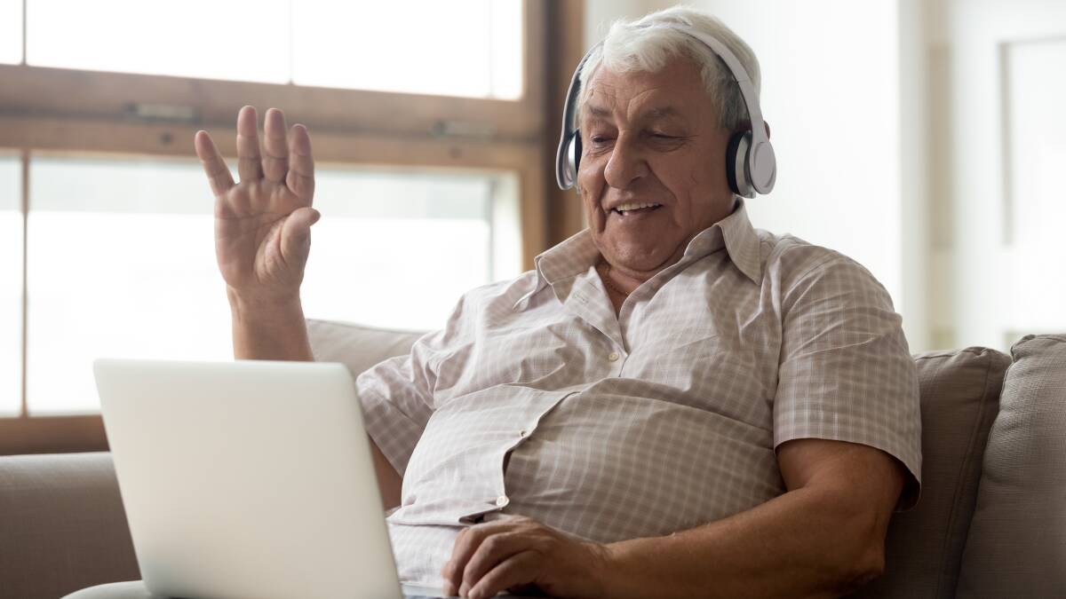 A gentleman wearing headphones while watching content on a laptop. Shutterstock picture.