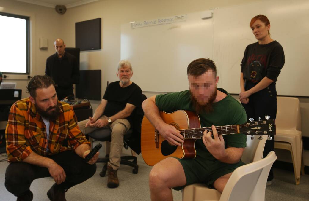 William Crighton working with an inmate guitarist as musos Ben Leece, John Schumann and Julieanne Crighton look on. Picture by Simone De Peak.