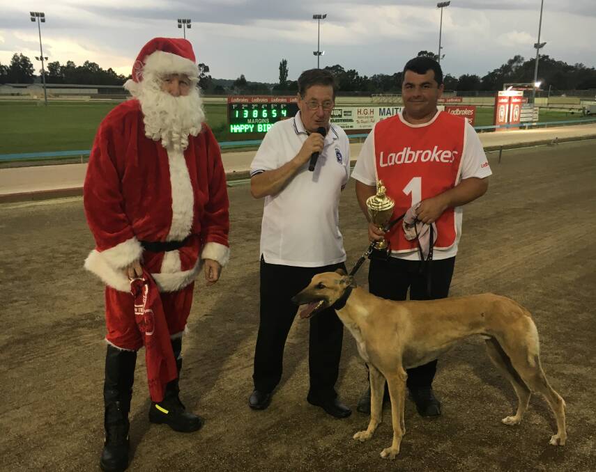 CHRISTMAS CUP: Santa joined with Maitland Greyhounds director Gary Minter to present the Maitland Christmas Cup to Oxley Rebel and trainer Darren Sultana.
