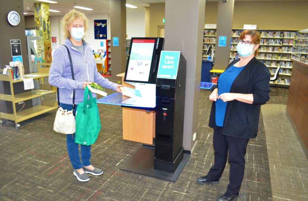 WELCOME BACK: Kurri Kurri Library customer Jacky Barlow and library customer service officer Lana Sadler on Monday.