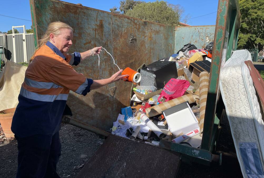 CLEAN-UP BEGINS: Abermain resident Michelle Beauchamp throws flood-damaged items into a skip on Friday. Picture: Krystal Sellars